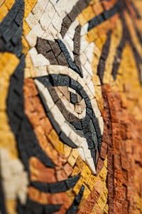Intricate mosaic artwork featuring a tiger's eye in warm earthy tones — detailed craftsmanship highlights the vibrant textures.