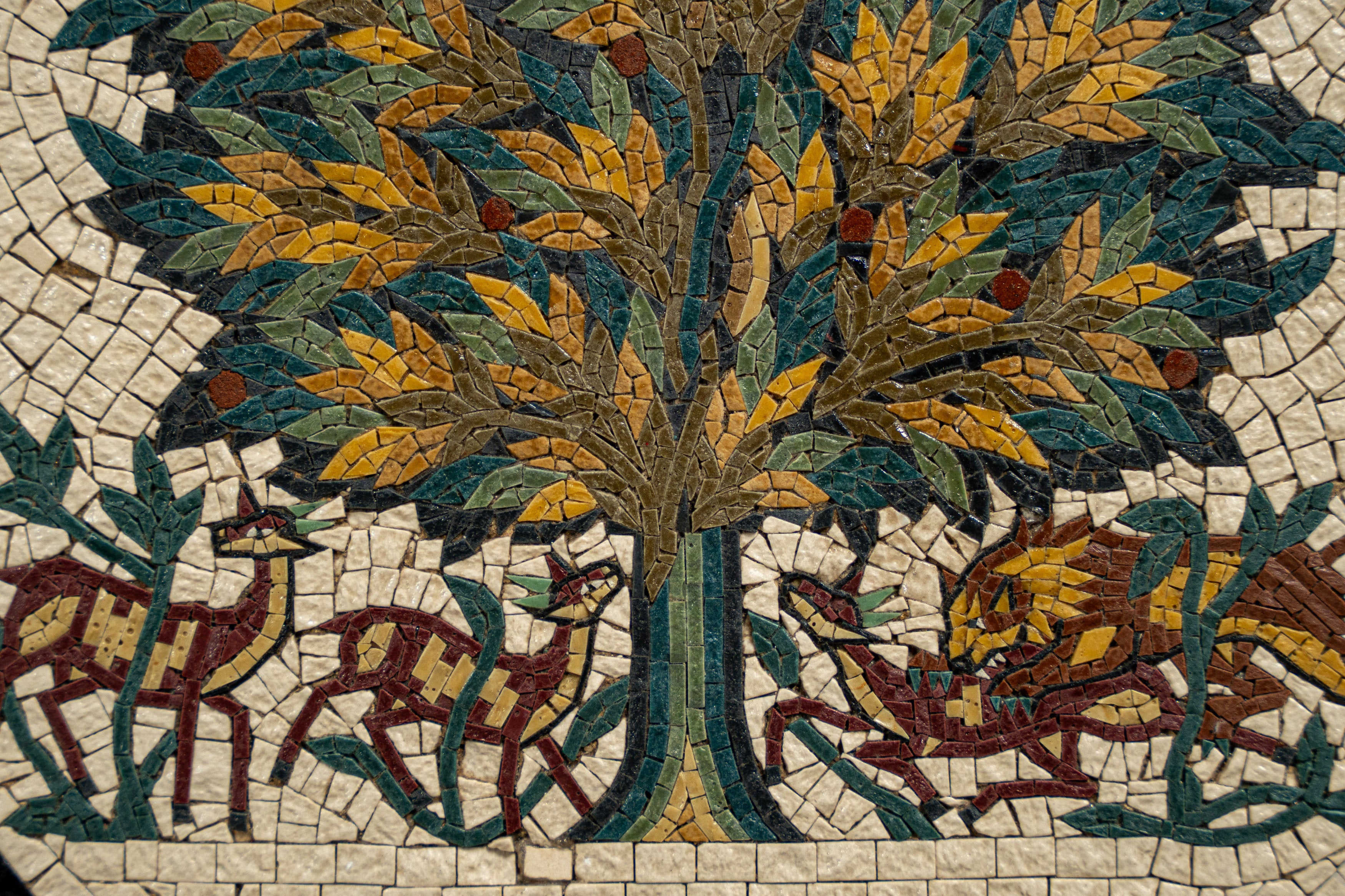Intricate mosaic art featuring a vibrant tree surrounded by stylized animals in earthy tones and rich textures.