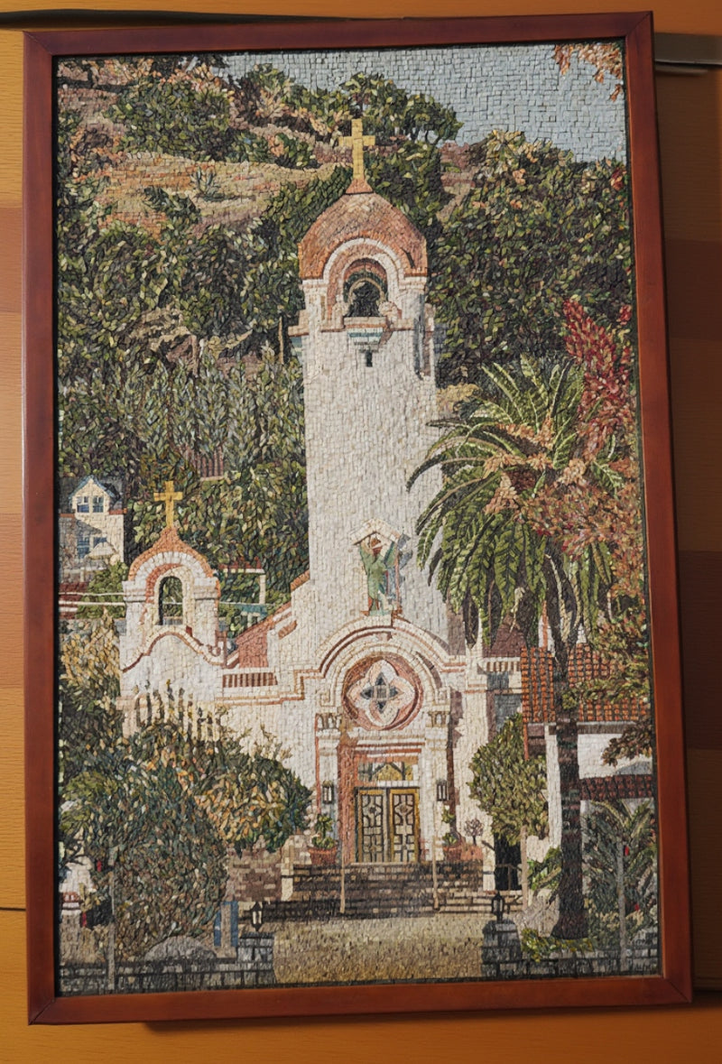 Intricate mosaic artwork depicting a serene church surrounded by lush greenery — vibrant colors and detailed textures enhance the scene.
