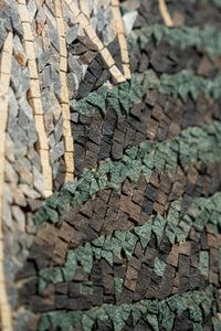 Intricate mosaic art piece featuring textured green and brown stone tiles arranged in a flowing, natural pattern.