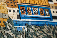 Intricate mosaic artwork featuring vibrant blue and earthy tones — detailed tiles create a textured landscape design
