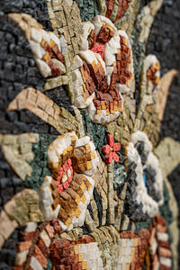 Intricate floral mosaic art piece featuring vibrant red and cream flowers against a dark background — exquisite craftsmanship in stone.