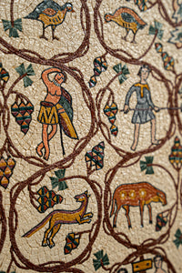 Intricate mosaic artwork featuring vibrant figures and animals on a textured stone background — a stunning historical depiction.