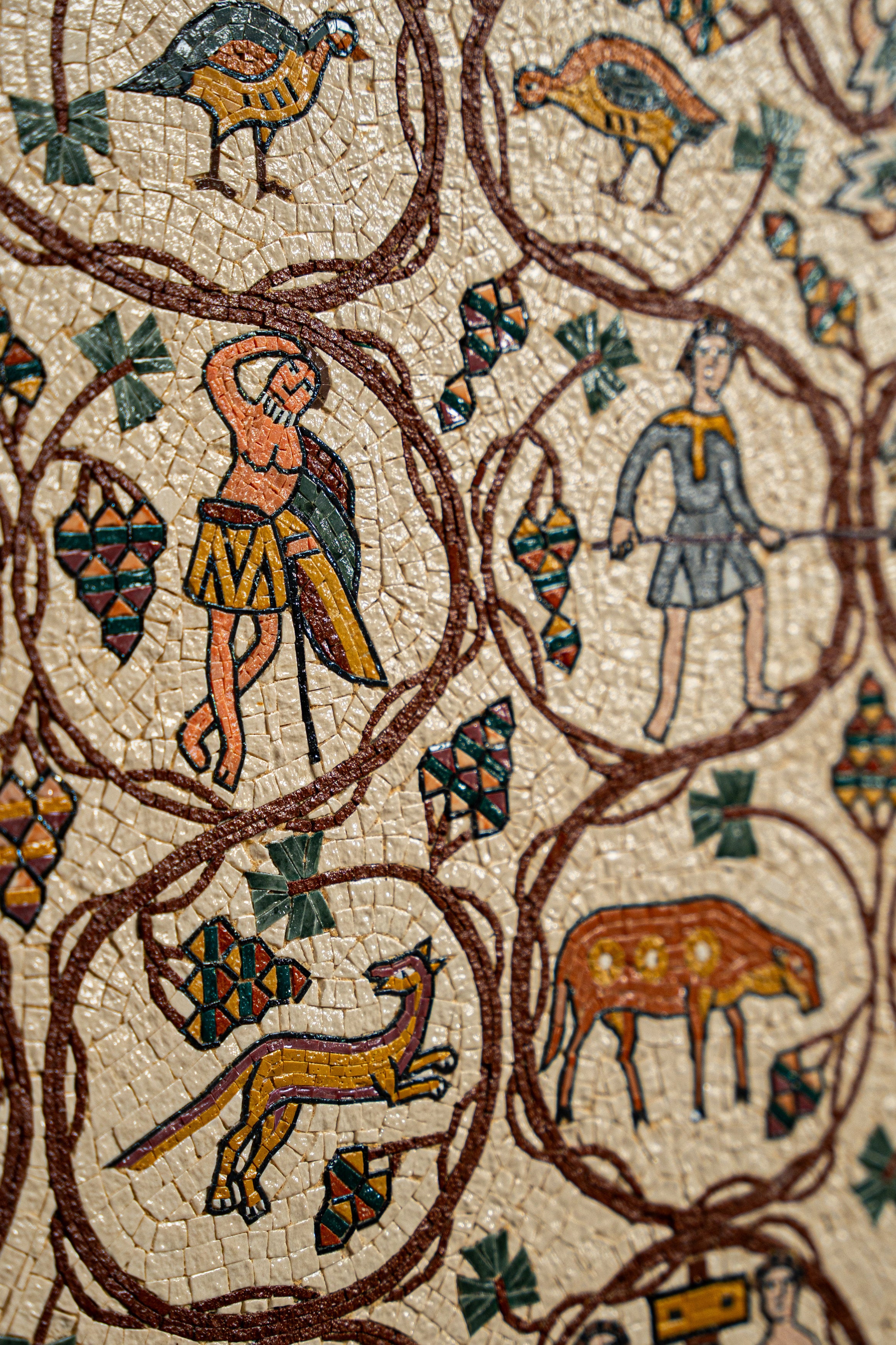 Intricate mosaic artwork featuring vibrant figures and animals on a textured stone background — a stunning historical depiction.