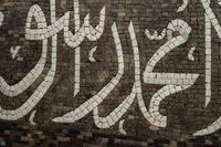 Intricate mosaic tile art featuring elegant calligraphy in earthy tones — a stunning blend of craftsmanship and cultural heritage.