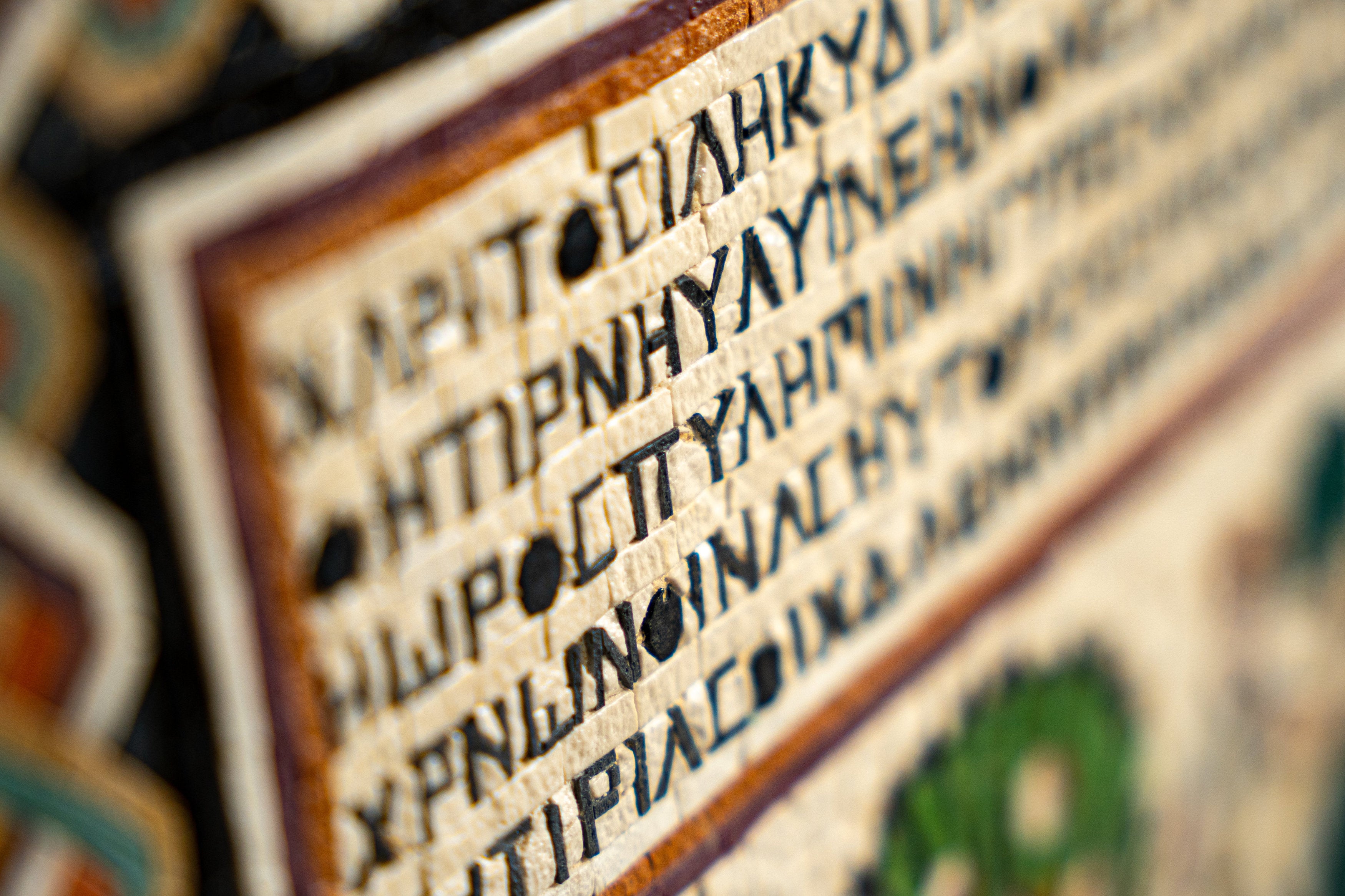 Intricate tapestry featuring ancient script on textured fabric — a rich display of historical artistry and craftsmanship.