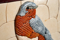 Intricate ceramic wall art featuring a textured bird design in earthy tones — a blend of warm reds and cool blues.