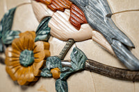 Intricate wall art featuring a carved bird and vibrant flowers in earthy tones — detailed craftsmanship with a textured finish