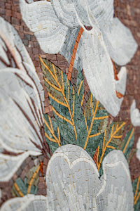 Intricate mosaic wall art featuring white flowers and green leaves — handcrafted tiles create a textured floral design.