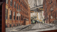 Vibrant mosaic artwork depicting a Brooklyn street scene with detailed brick buildings and a bridge in the background