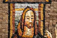 Intricate mosaic artwork featuring a figure with a detailed expression, crafted from various textured stone tiles in warm hues.