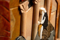Intricate mosaic art piece featuring warm earth tones and textured stone elements, showcasing detailed craftsmanship.