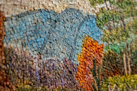 Vibrant mosaic artwork featuring textured tiles in shades of blue, orange, and green — depicting a serene landscape scene