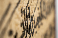 Intricate wall art featuring textured black patterns on a natural beige background — a striking blend of modern and rustic design.