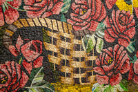 Intricate mosaic featuring a woven basket surrounded by vibrant red roses and lush green leaves — a stunning artistic display.