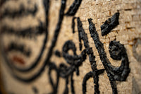Intricate textured wall art featuring black calligraphy on a natural wooden background — a unique blend of craftsmanship and design.