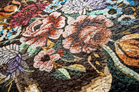 Intricate floral mosaic art featuring vibrant roses and blue flowers on a textured dark background — a stunning decorative piece.