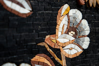 Intricate mosaic flower design crafted from natural stone in earthy tones against a textured black background
