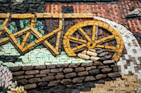 Intricate mosaic artwork featuring a golden wheel crafted from natural stone tiles — showcasing vibrant earthy tones and textures.