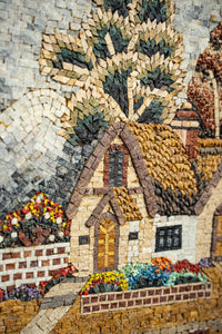 Intricate mosaic artwork depicting a charming cottage surrounded by vibrant flowers — textured tiles create a detailed landscape.