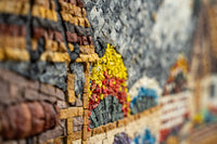 Intricate mosaic artwork featuring vibrant yellow, red, and blue tiles — a textured display of craftsmanship and creativity.