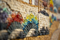 Intricate mosaic artwork featuring vibrant colors and textured stones, showcasing an elegant arch design with rich detail.