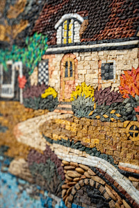 Intricate mosaic artwork depicting a charming cottage with vibrant autumn foliage and a winding stone path.