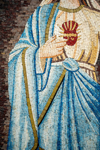 Intricate mosaic art featuring a figure in flowing blue robes with a heart motif, showcasing detailed craftsmanship and vibrant colors.