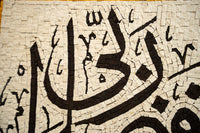 Intricate mosaic art featuring Arabic calligraphy with textured black and cream tiles creating a captivating design