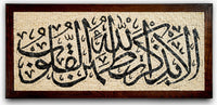 Intricate calligraphy art piece framed in dark wood — featuring elegant Arabic script on a textured cream background