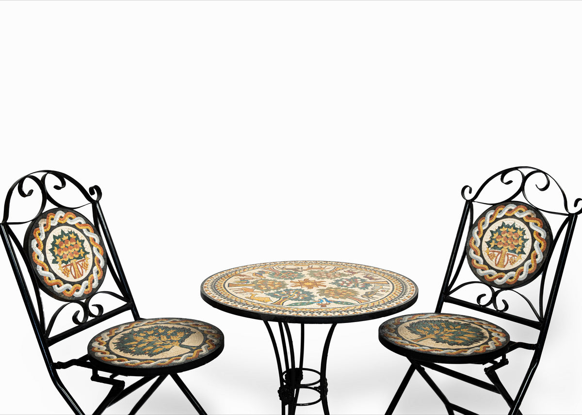 Intricate metal bistro table with hand-painted ceramic top and two matching chairs featuring decorative seat cushions