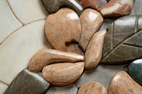 Natural stone mosaic tiles in earthy tones with smooth, rounded edges — ideal for creating a rustic, textured surface