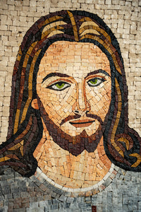 Intricate mosaic artwork depicting a serene figure with flowing hair and striking green eyes — crafted from colorful stone tiles.
