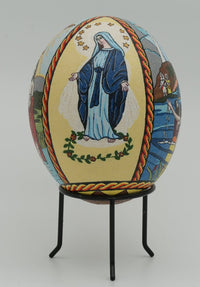 Intricately designed decorative egg featuring a Virgin Mary illustration with vibrant colors and detailed patterns on a stand