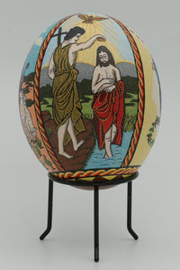 Intricately designed decorative egg featuring a colorful scene of baptism — vibrant imagery on a smooth ceramic surface