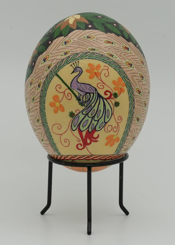 Intricately designed decorative egg featuring a peacock motif in vibrant colors, displayed on a sleek black stand.