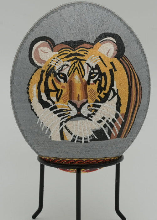 Intricate woven wall art featuring a majestic tiger's face on a grey background — showcasing vibrant colors and detailed textures.
