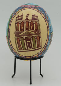 Intricately designed decorative egg featuring a detailed architectural motif — vibrant colors on a smooth surface.