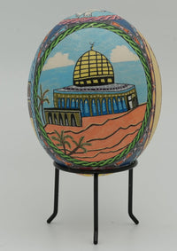 Intricately painted decorative egg featuring a vibrant scene of a domed building against a desert backdrop — a unique art piece