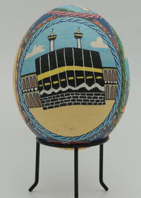 Intricately painted decorative egg featuring the Kaaba in Mecca with vibrant colors and detailed floral motifs surrounding it