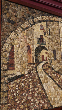 Intricate stone mosaic artwork depicting a rustic archway with earthy tones and textured pebbles creating a captivating scene