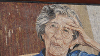 Intricate mosaic artwork depicting an elderly woman in a blue blouse, capturing her thoughtful expression with textured tiles.
