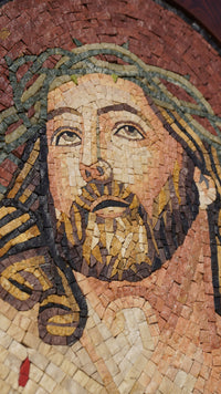 Intricate mosaic artwork featuring a serene expression — crafted from colorful stone pieces with detailed textures.