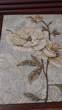 Intricate floral mosaic art featuring delicate white magnolias set against a soft grey background — a stunning display of craftsmanship.