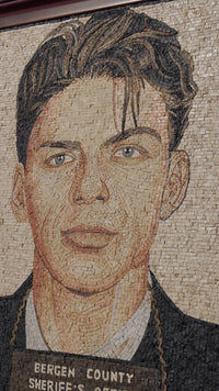 Detailed mosaic portrait of a young man with textured stone tiles showcasing a blend of warm tones and intricate craftsmanship