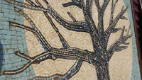 Intricate mosaic art featuring a stylized tree with textured bark and colorful leaves against a pale background