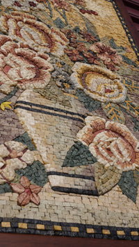 Intricate floral mosaic artwork featuring a vase adorned with roses in soft pastel tones — crafted from colorful stone tiles.