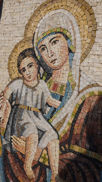 Vibrant mosaic artwork depicting a mother holding a child — intricate tile patterns in earthy tones and soft textures.
