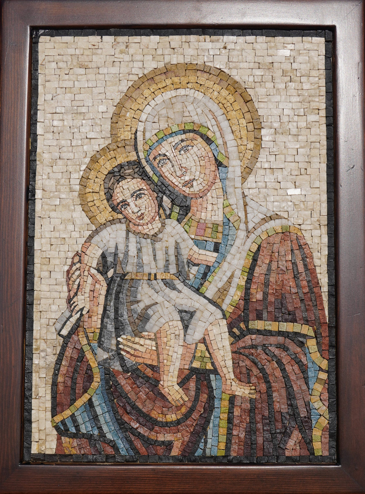 Intricate mosaic art depicting a mother and child in warm earth tones — detailed craftsmanship showcasing textured tiles.