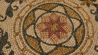 Intricate mosaic tile design featuring a star pattern in earthy tones of beige, brown, and green, showcasing artisan craftsmanship.